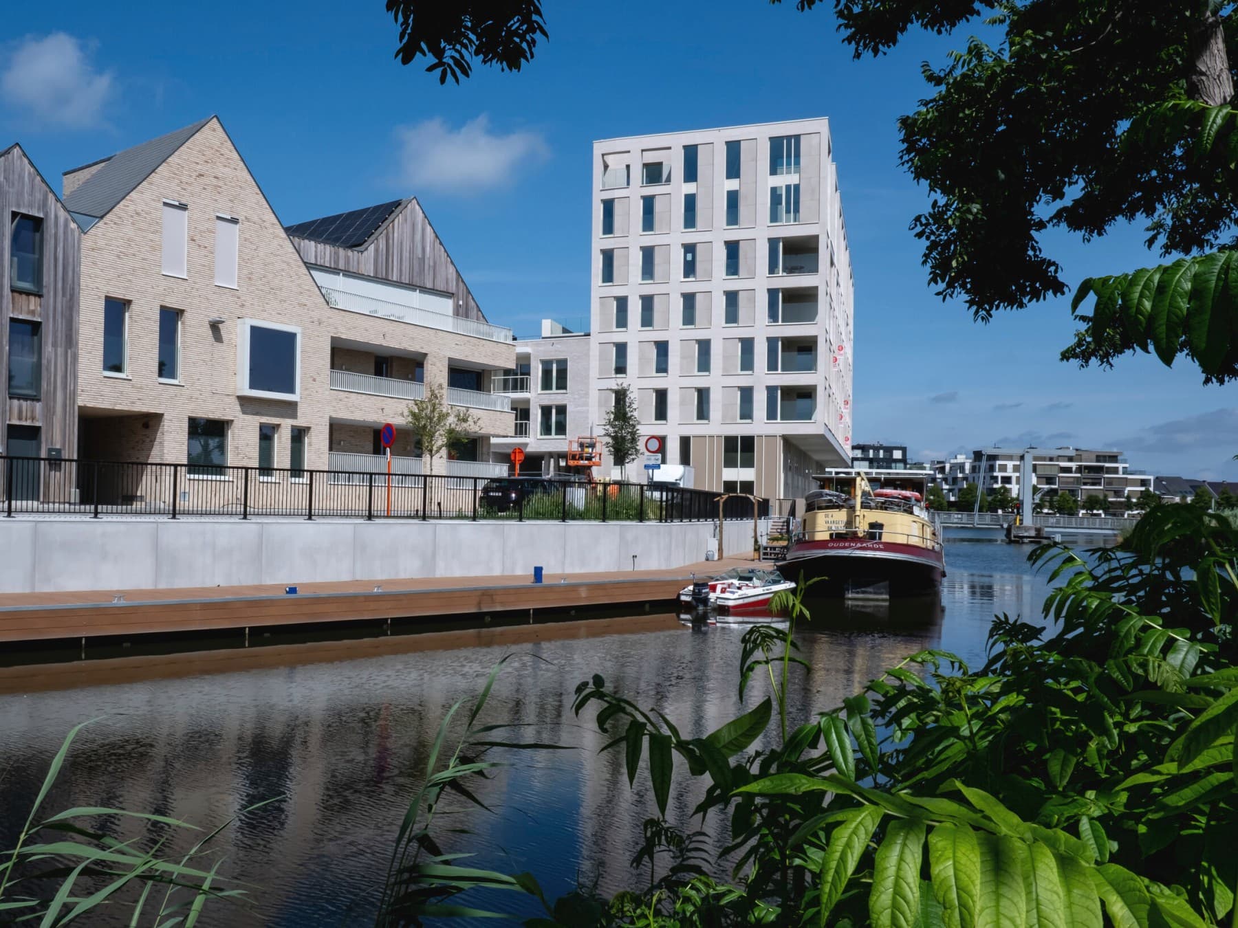 Complexe résidentiel Bord'eau avec des appartements au bord de l'eau, avec un bateau en arrière-plan.