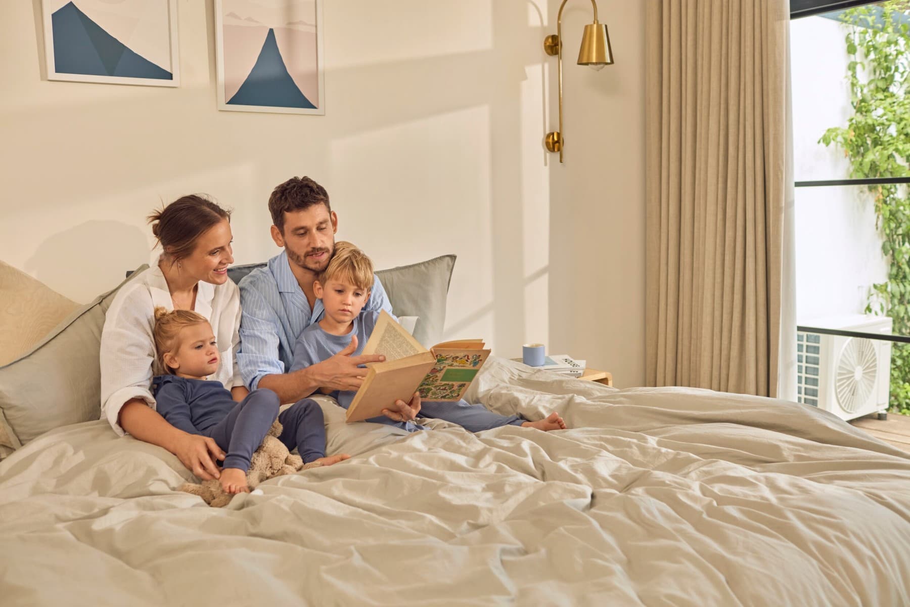 Une famille lit un livre sur un lit