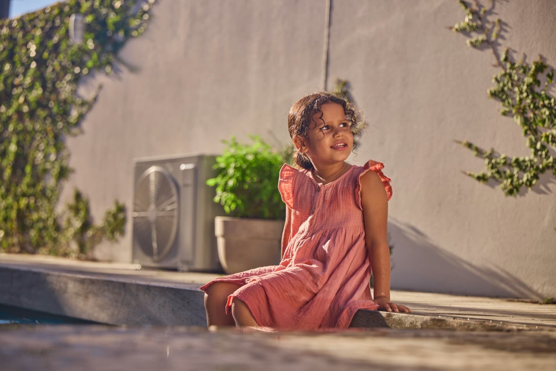 Une fille est assise au bord d'une piscine