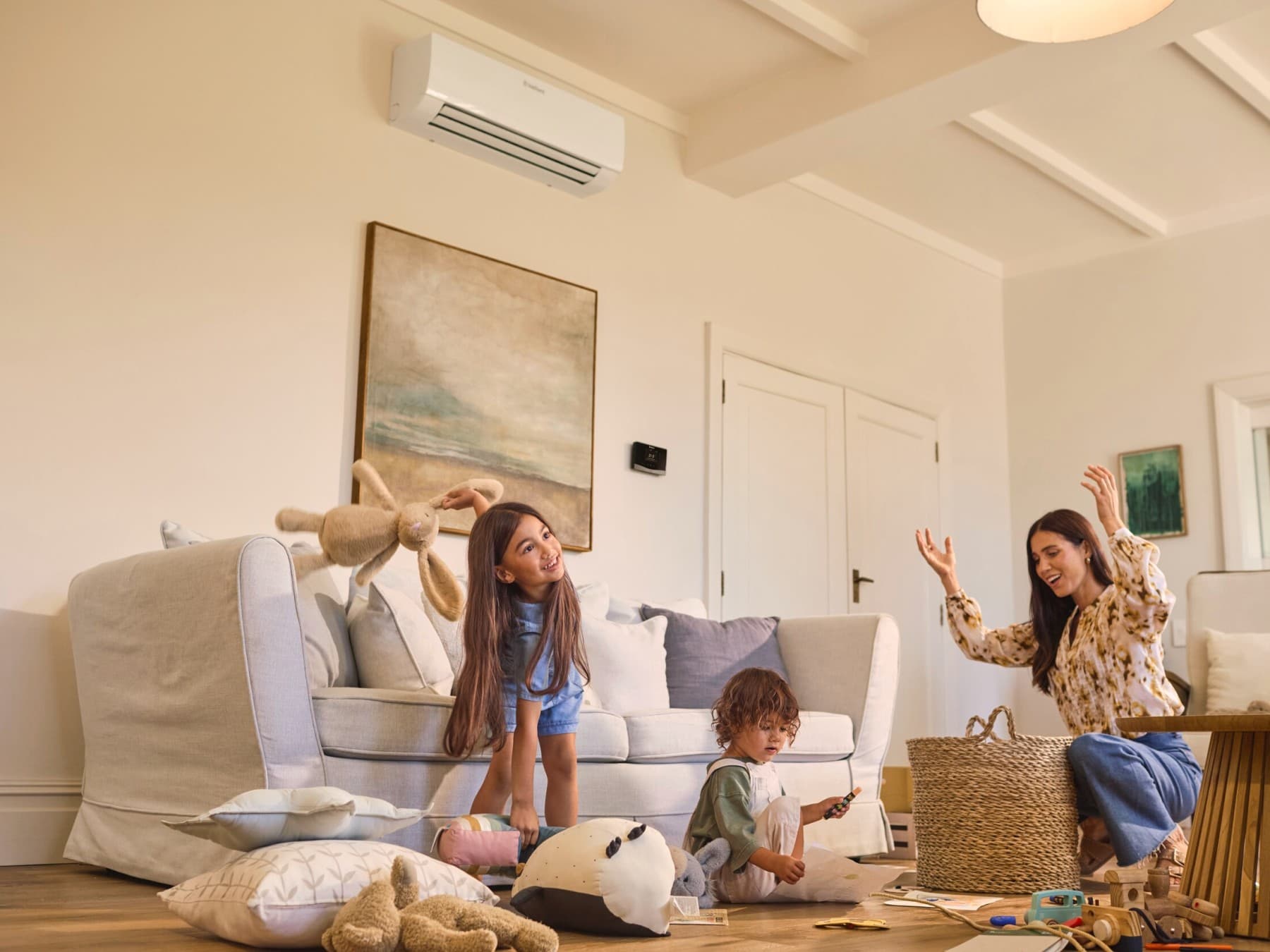 Gezin speelt in een living met bovenaan de muur een airco wandmodule