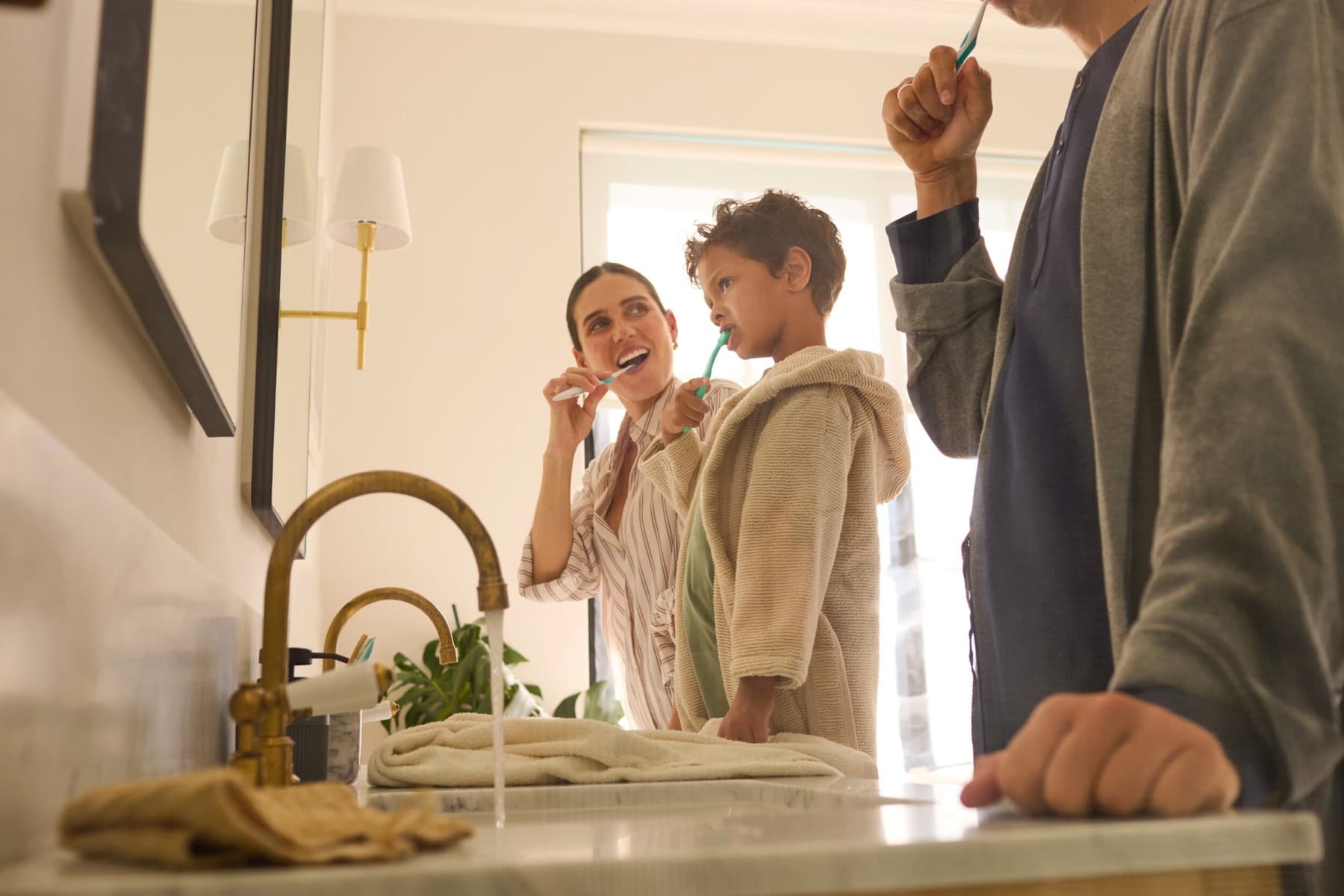 Une famille se brosse les dents dans la salle de bain.