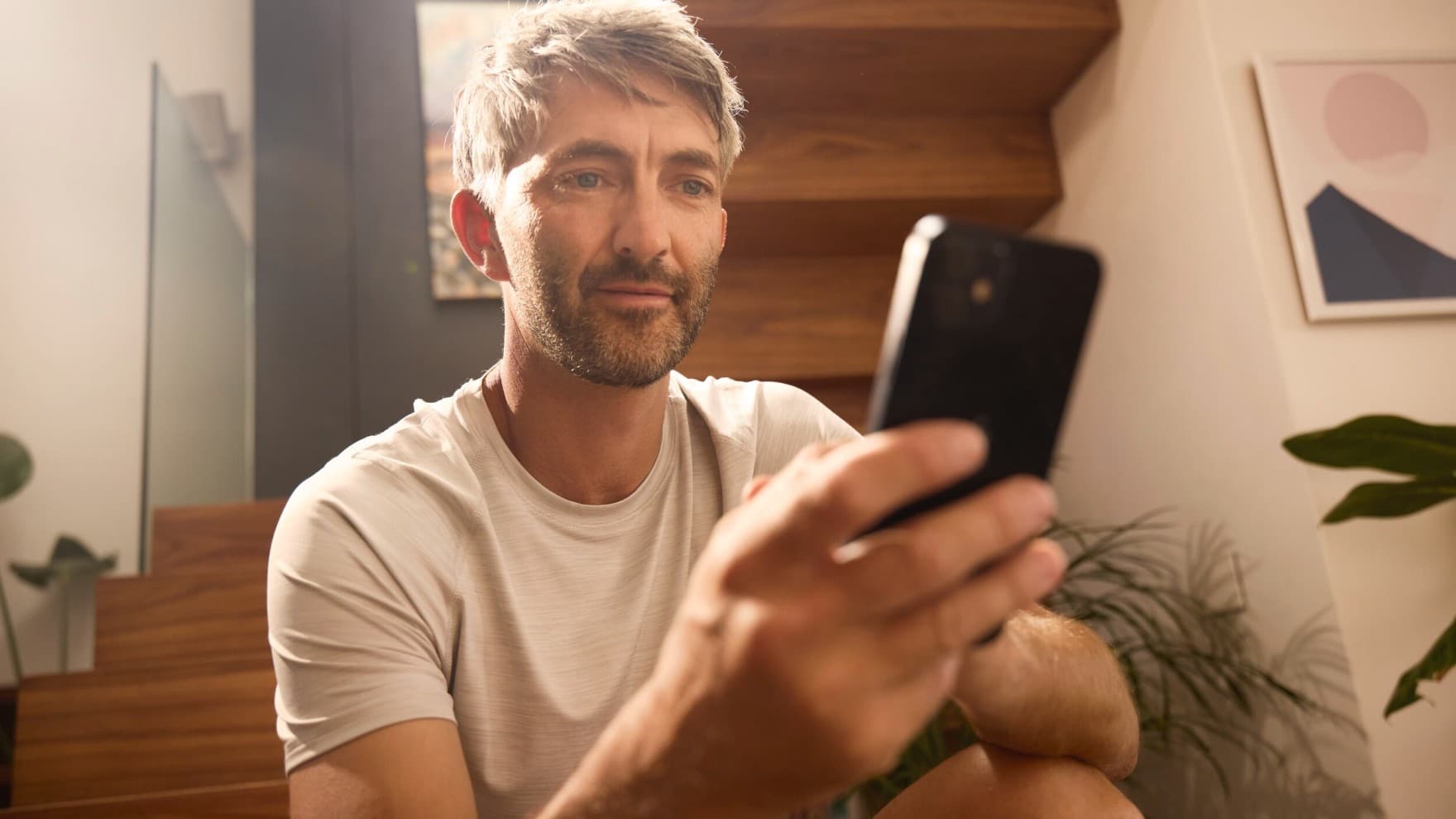 Een man bedient zijn verwarmingssysteem via een app