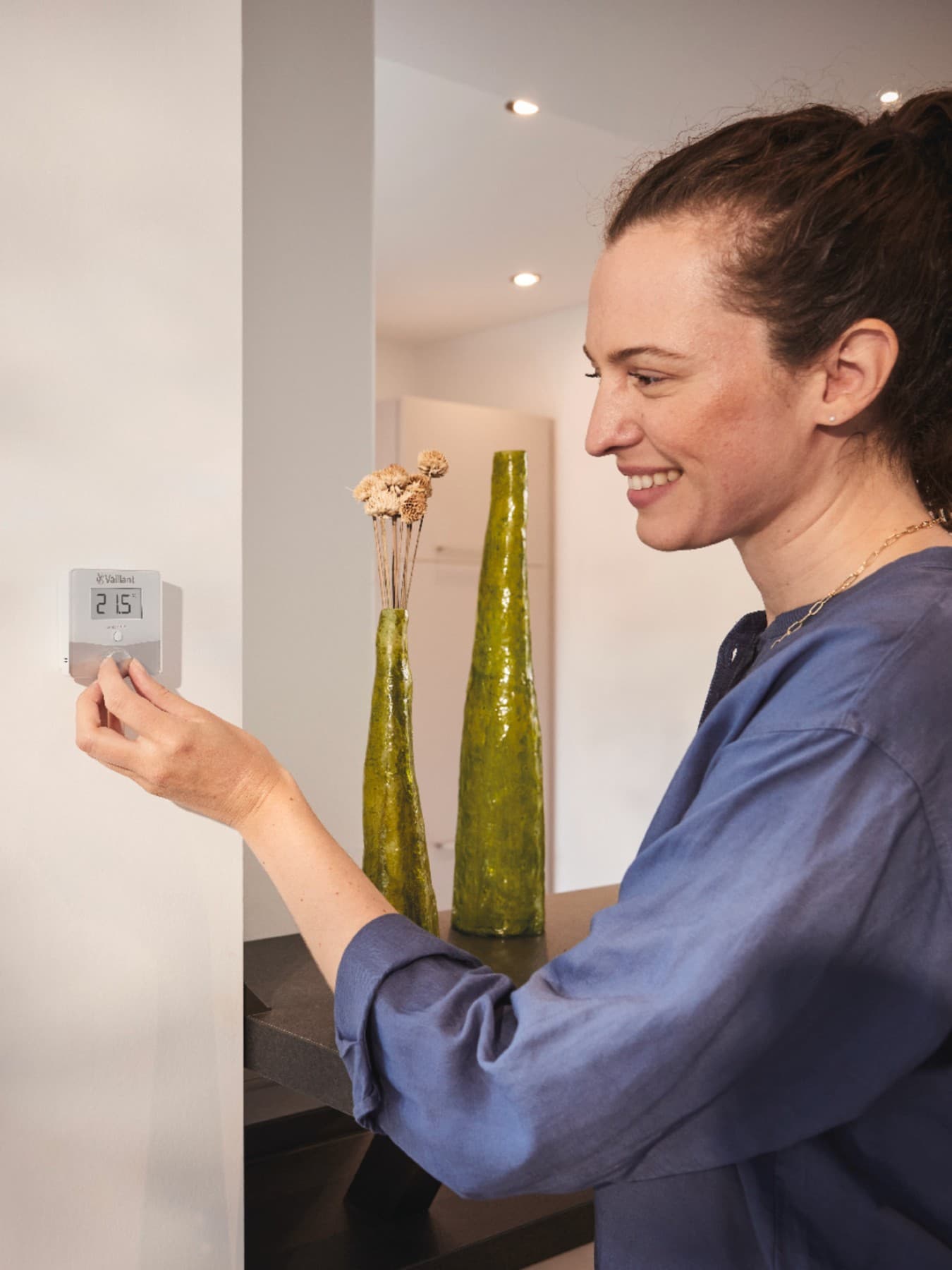 Une femme règle la température d'un thermostat