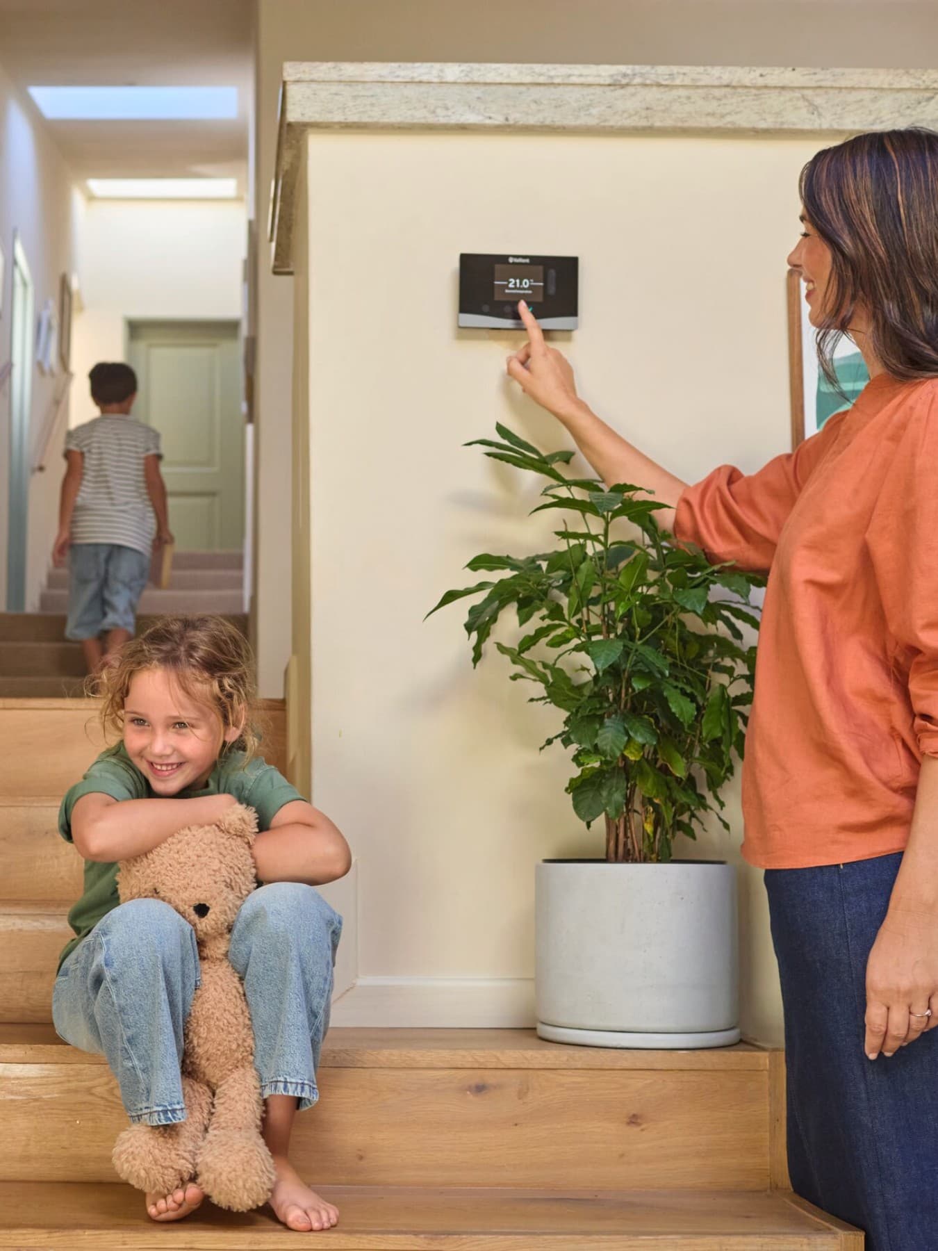 Une femme règle les paramètres du thermostat mural