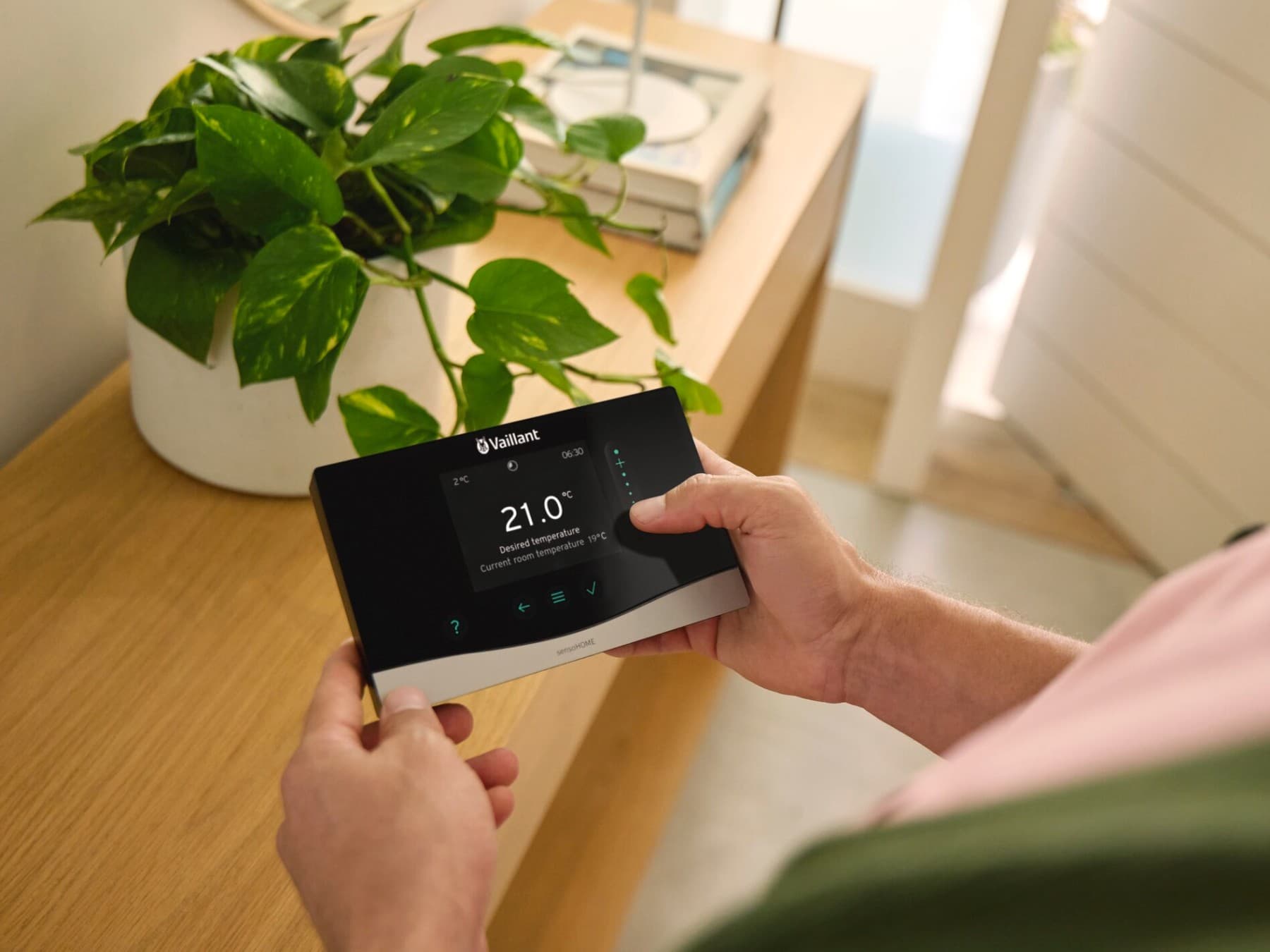 Hand houdt Vaillant thermostaat vast
