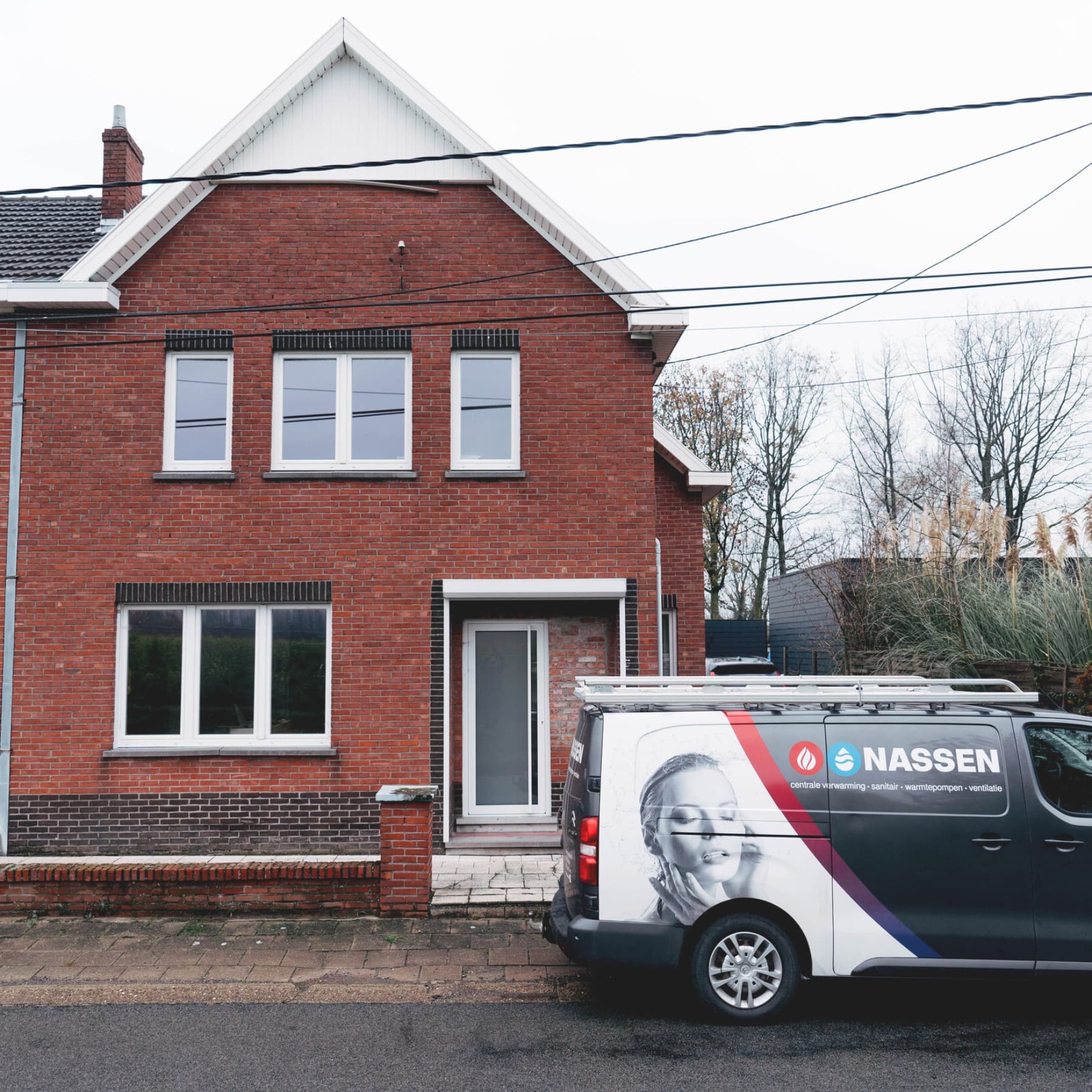 A pickup truck is parked in front of a red-brick building