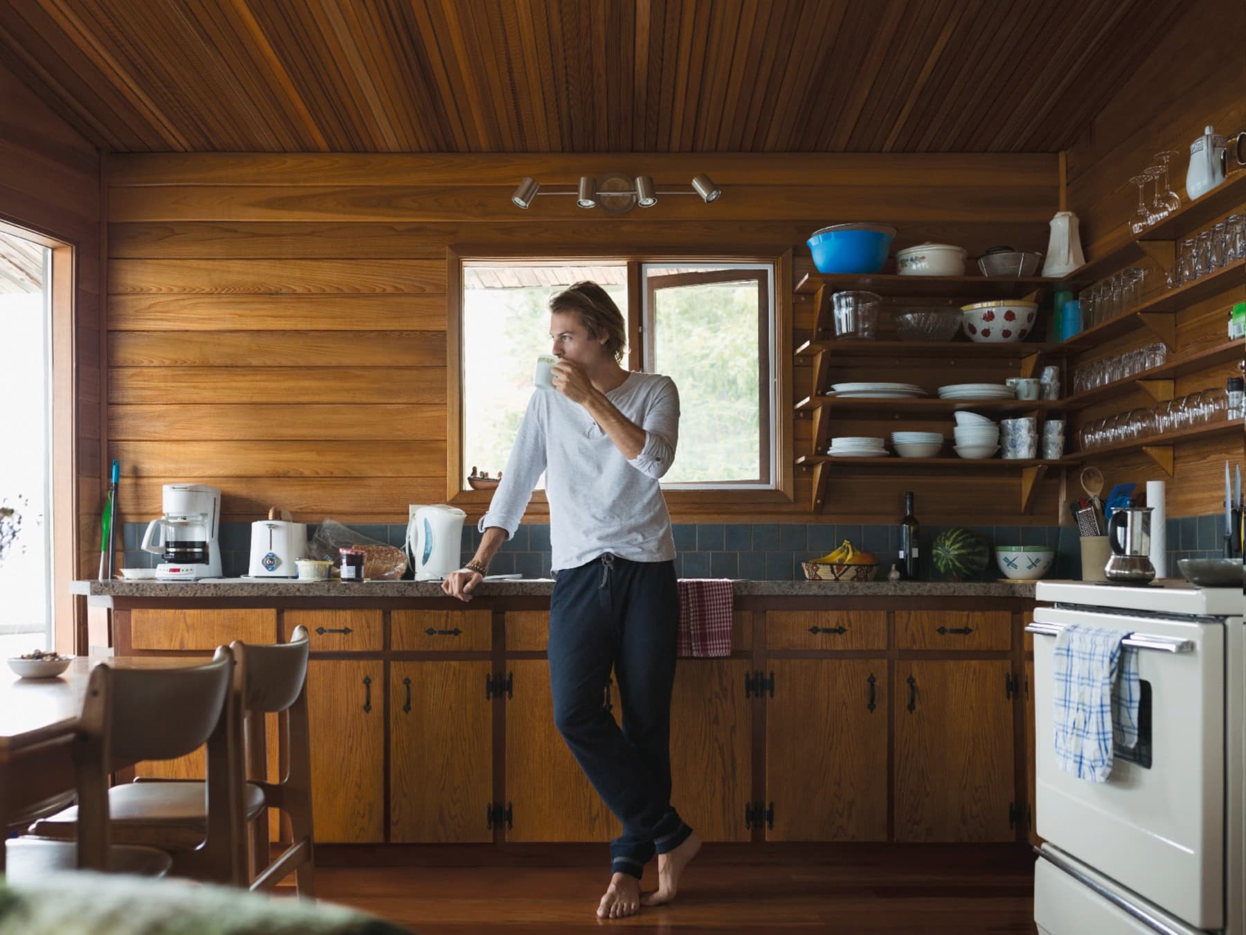 Un homme boit un verre dans un chalet