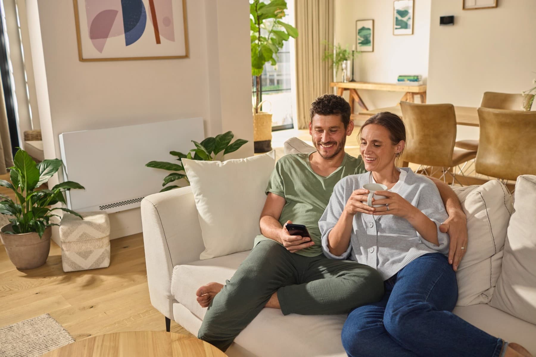Couple assis sur le canapé regardant un smartphone
