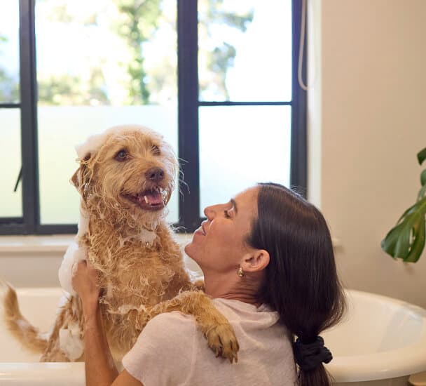 Frau badet ihren Hund