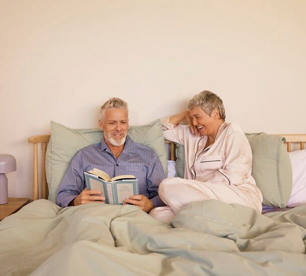 Een stel in bed dat een boek leest