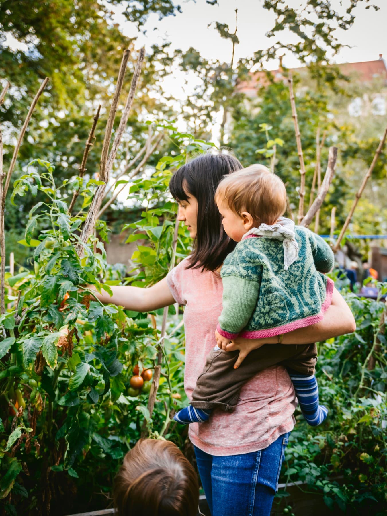 Femme avec un enfant dans les bras dans un potager
