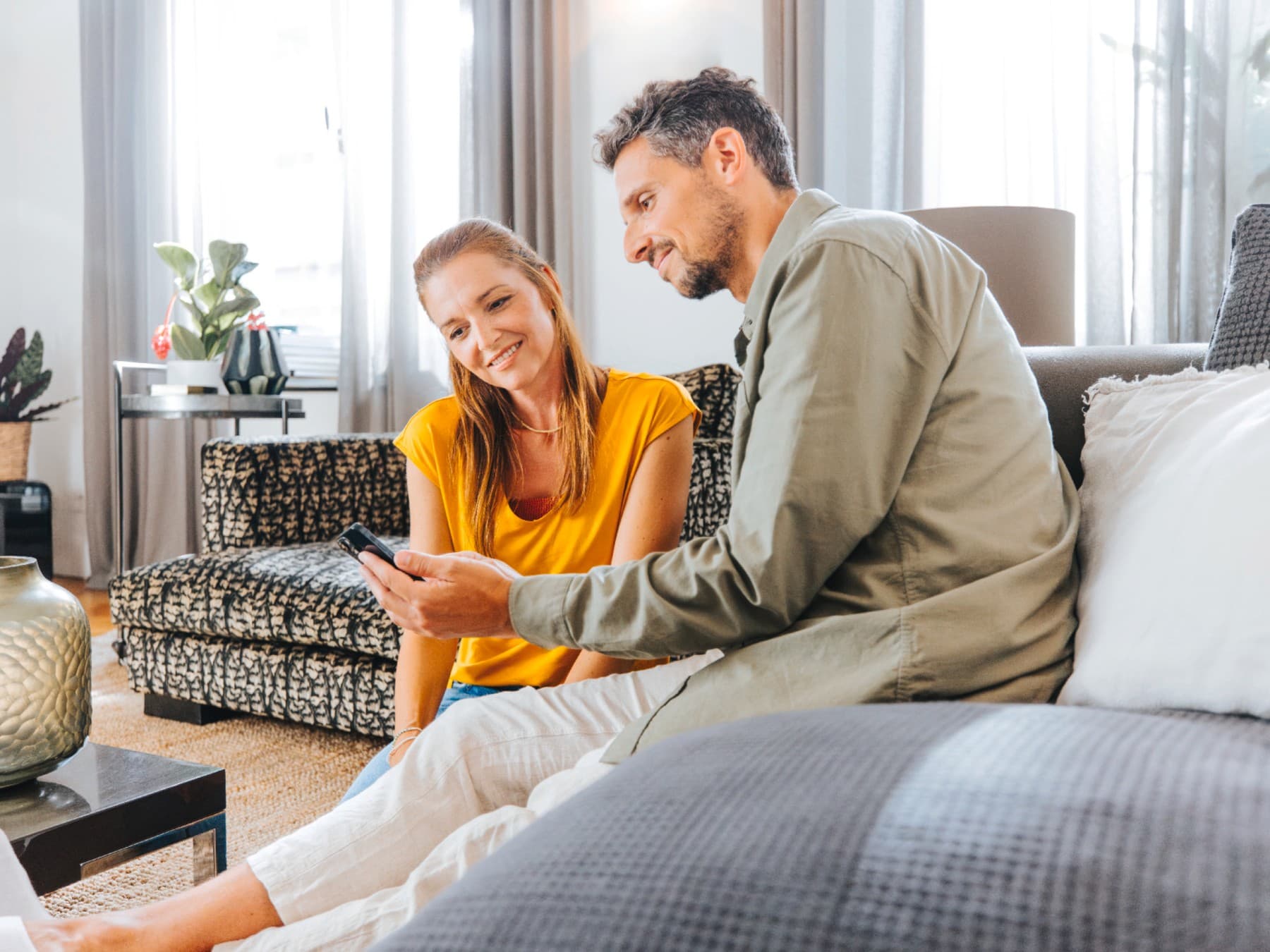 Koppel in de living met smartphone | Vaillant