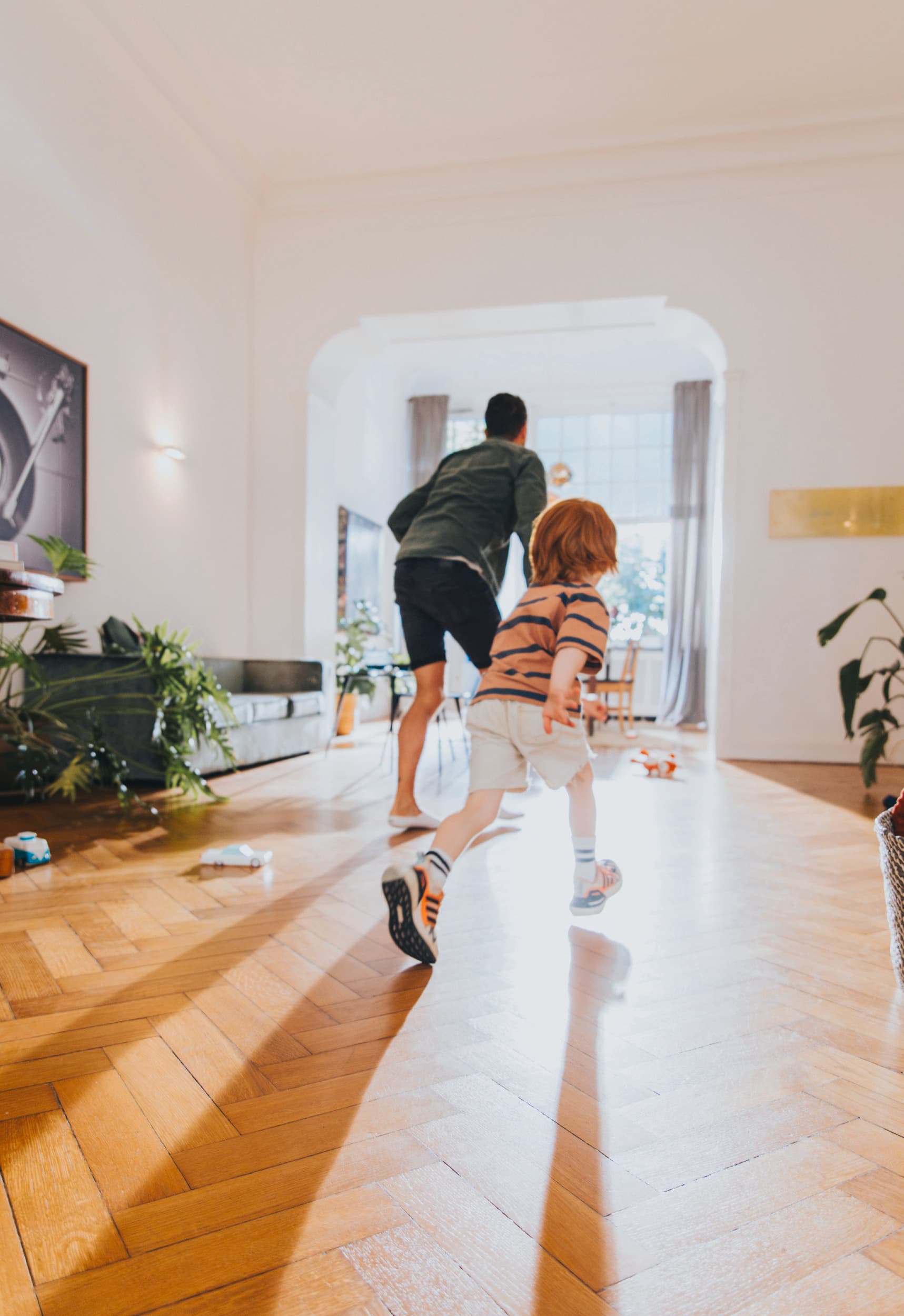 Un papa qui joue avec son fils dans le salon.