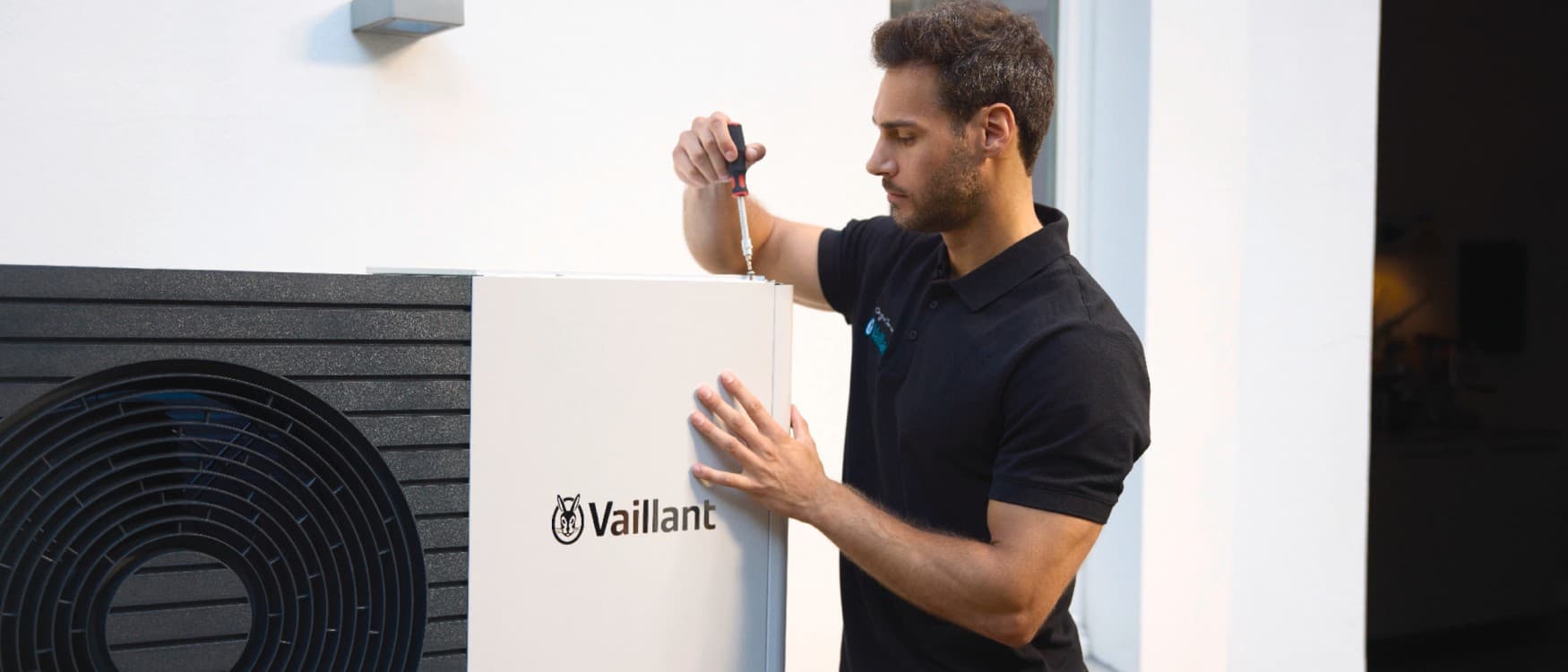 Un installateur Vaillant travaille sur une pompe à chaleur.