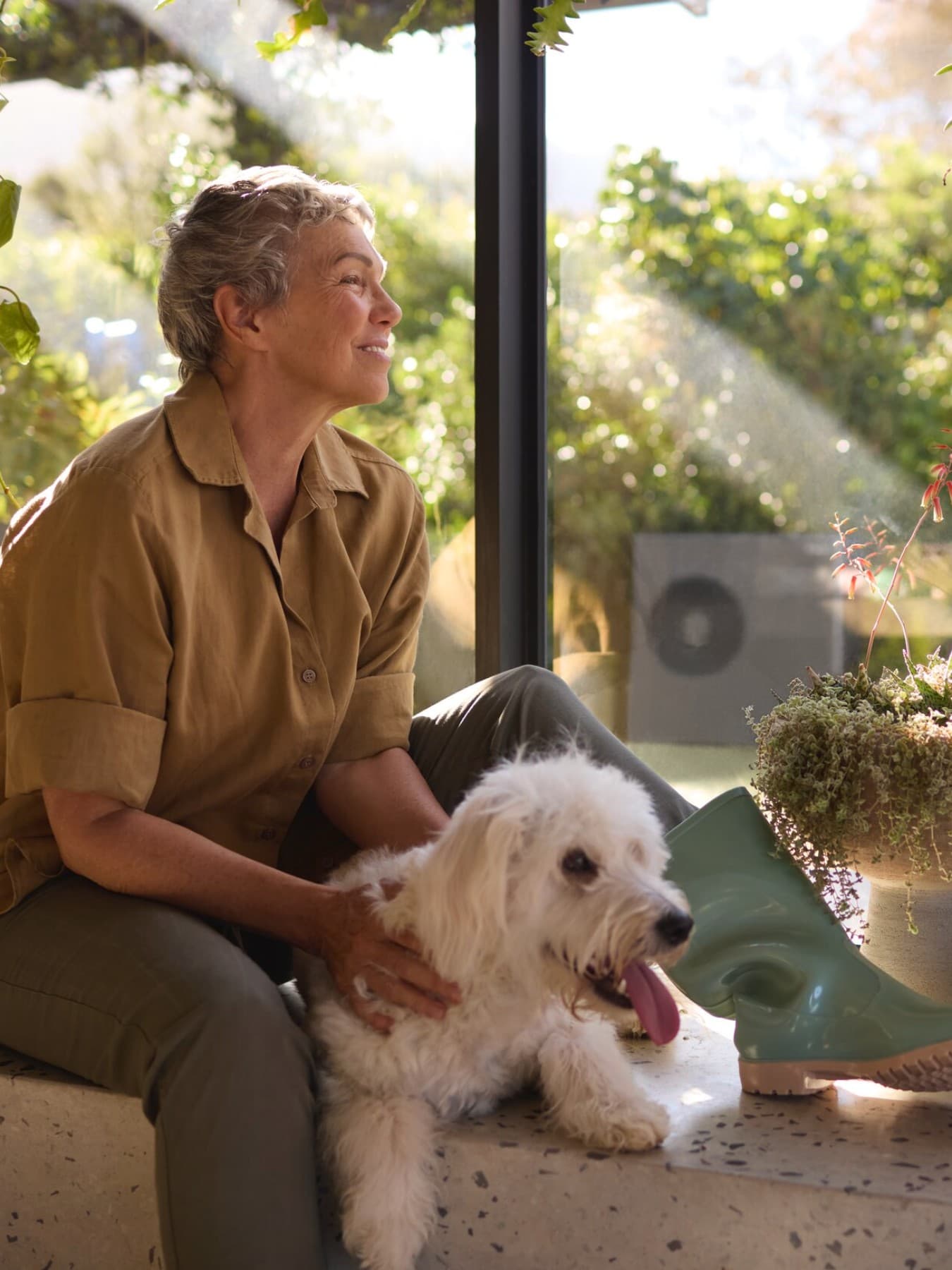 Pompe à chaleur Vaillant aroTHERM plus dans le jardin et femme assise par terre