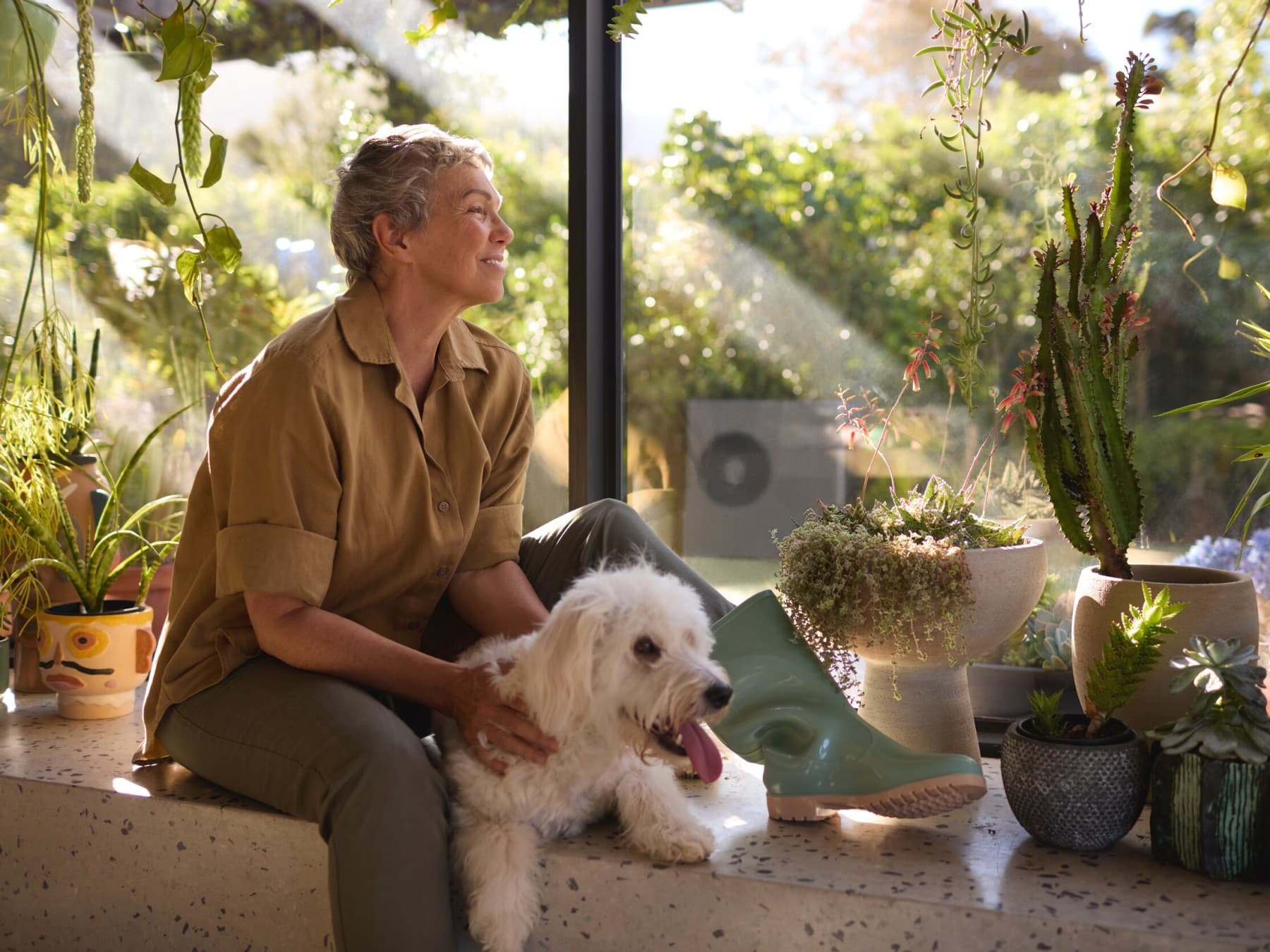 Pompe à chaleur Vaillant aroTHERM plus dans le jardin et femme assise par terre