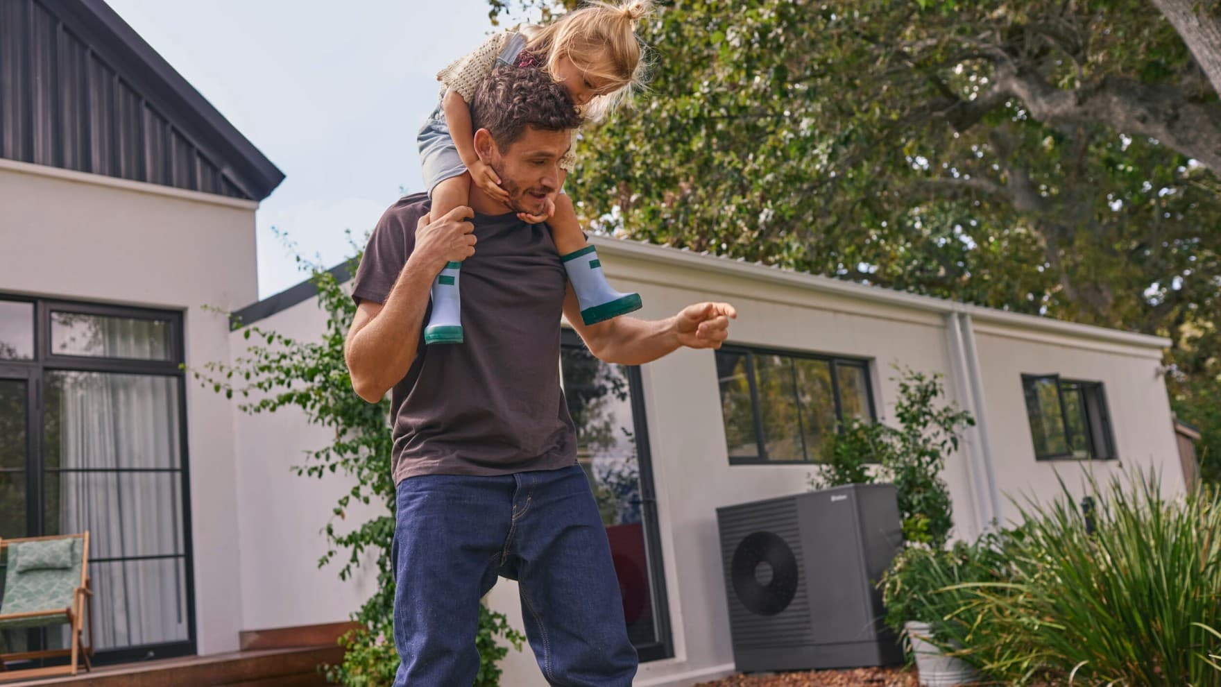 Père et fille devant une pompe à chaleur