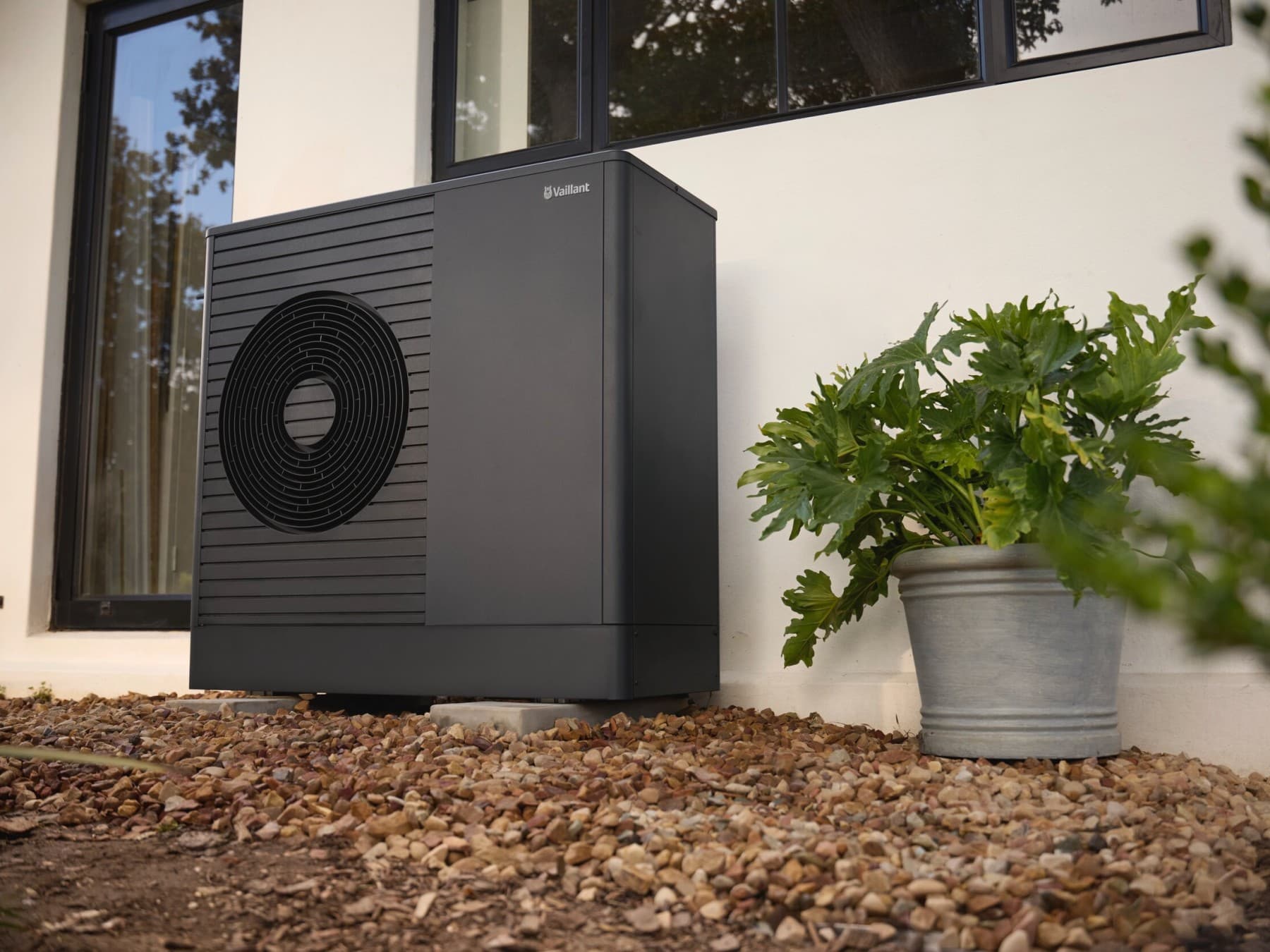 Pompe à chaleur Vaillant dans un jardin verdoyant.