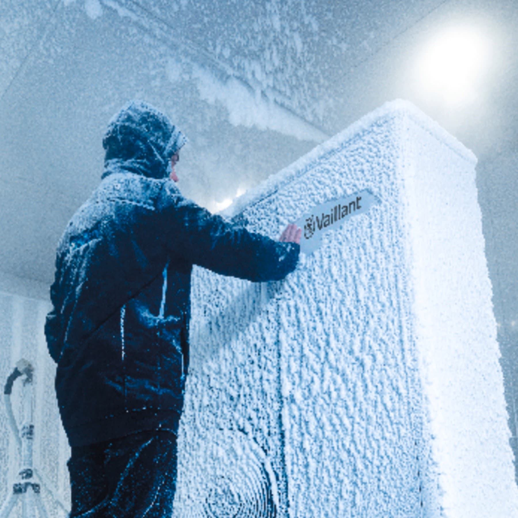 Man in winterjas voor bevroren Vaillant-apparaat
