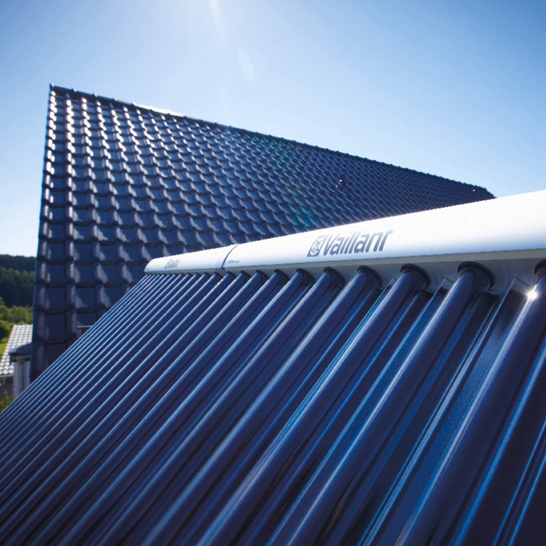 Gros plan sur un panneau solaire Vaillant avec un toit de couleur foncée en arrière-plan