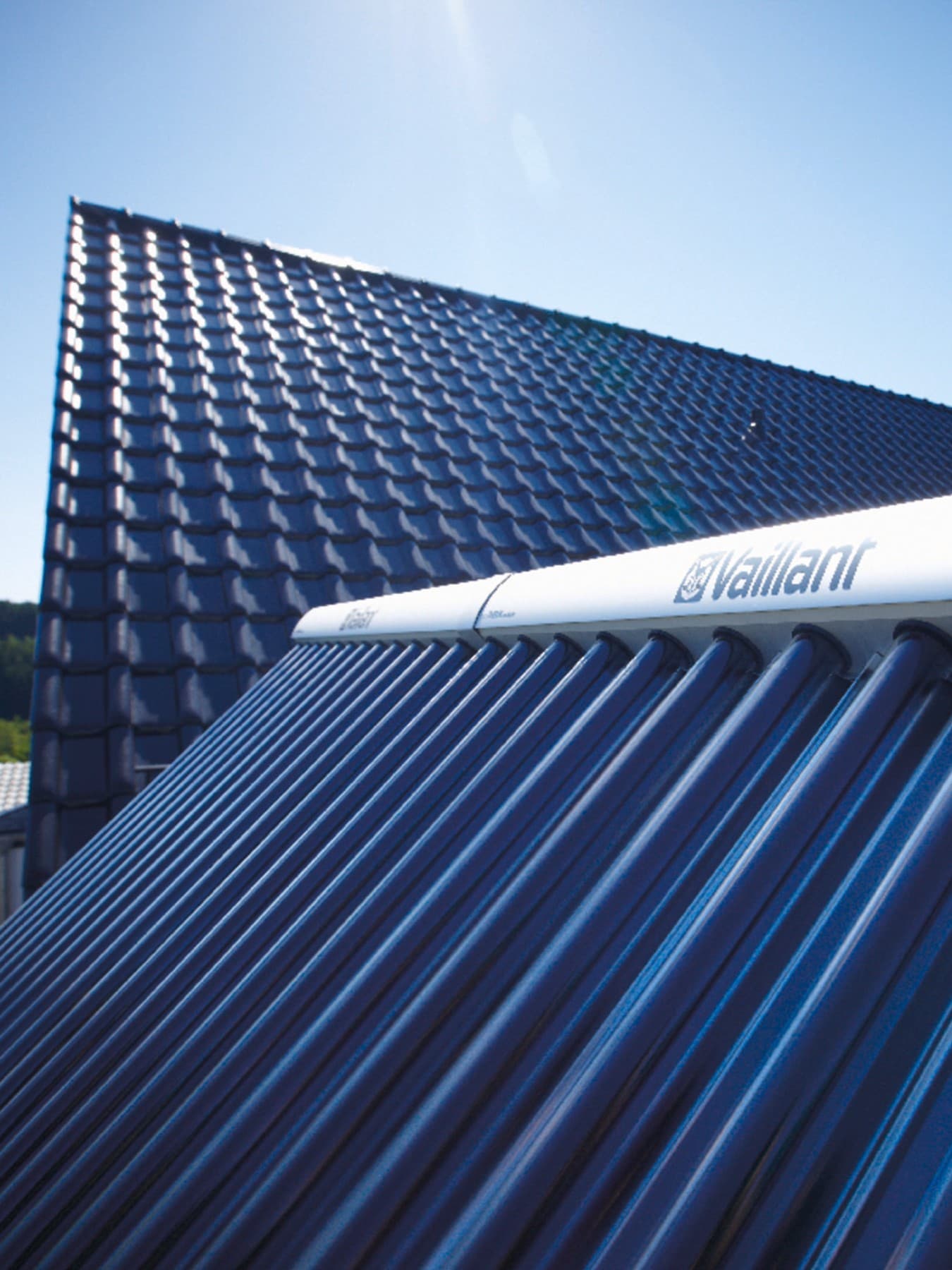 Gros plan sur un panneau solaire Vaillant avec un toit de couleur foncée en arrière-plan