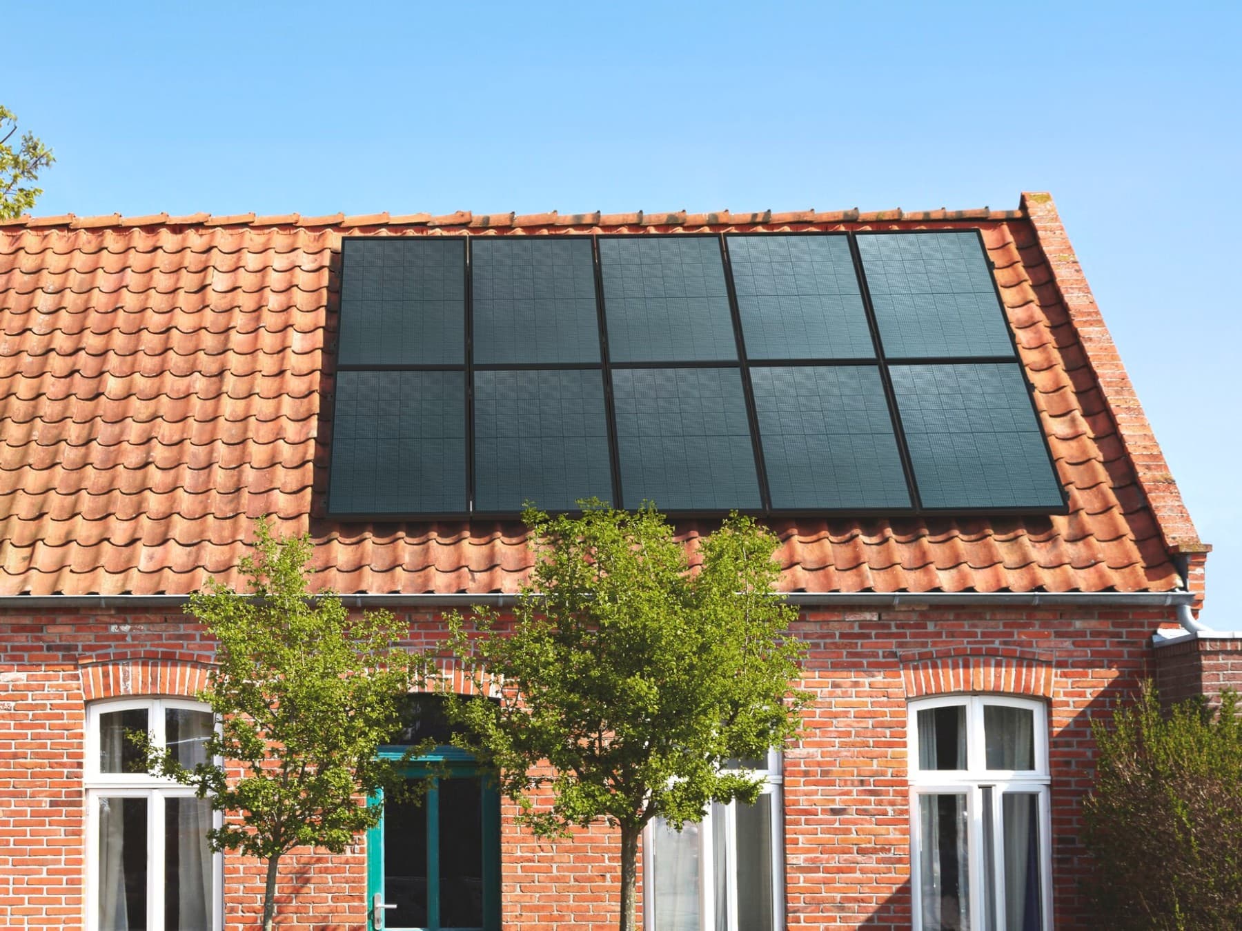 Maison avec un toit en tuiles orange et des panneaux solaires