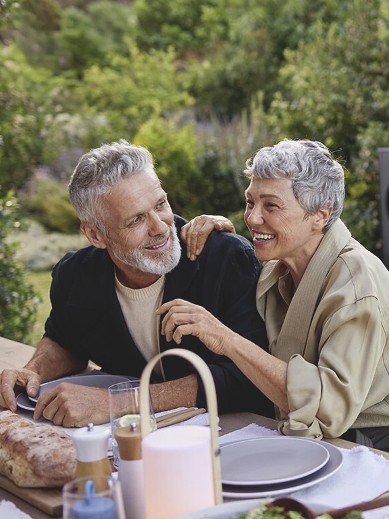 Un couple déjeune en terrasse; une pompe à chaleur est visible en arrière-plan.