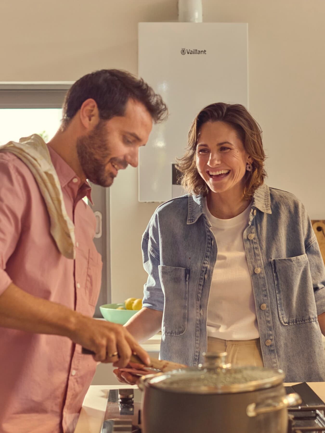 Un couple dans la cuisine, avec une chaudière à condensation au gaz à l'arrière