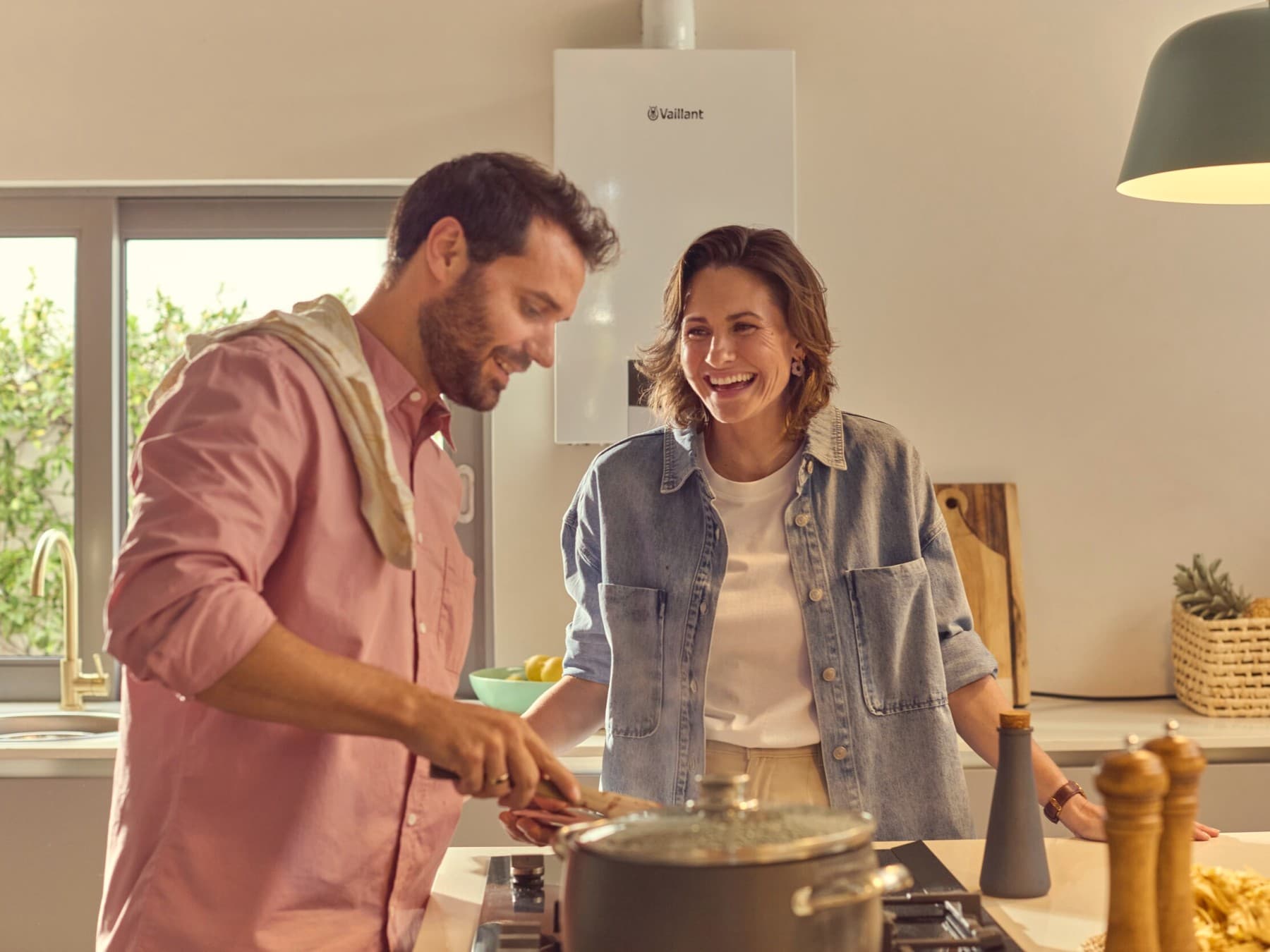 Un couple dans la cuisine, avec une chaudière à condensation au gaz à l'arrière